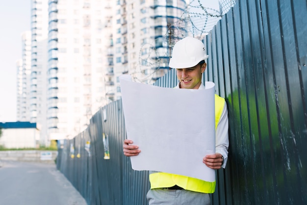 Medium shot young man with safety vest and helmet