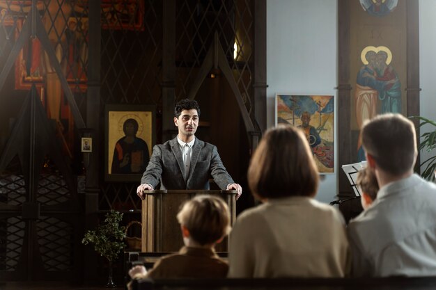 Medium shot young pastor preaching at church