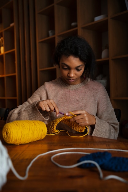 Medium shot young woman crocheting