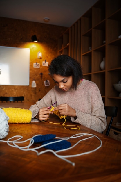 Free photo medium shot young woman crocheting