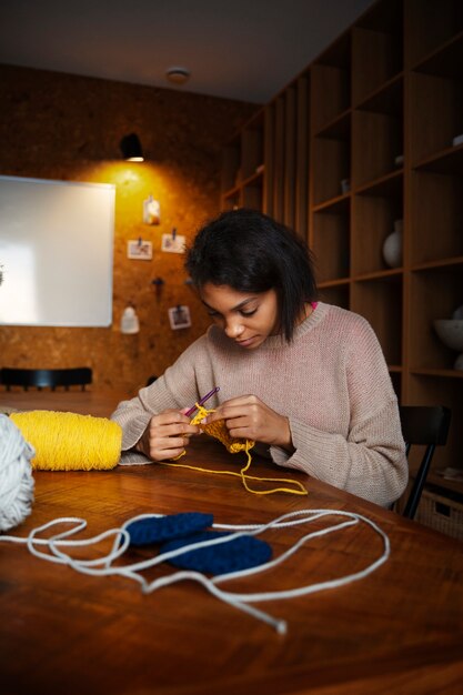 Medium shot young woman crocheting