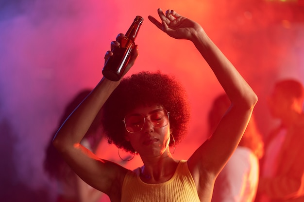 Free photo medium shot young woman dancing at techno party