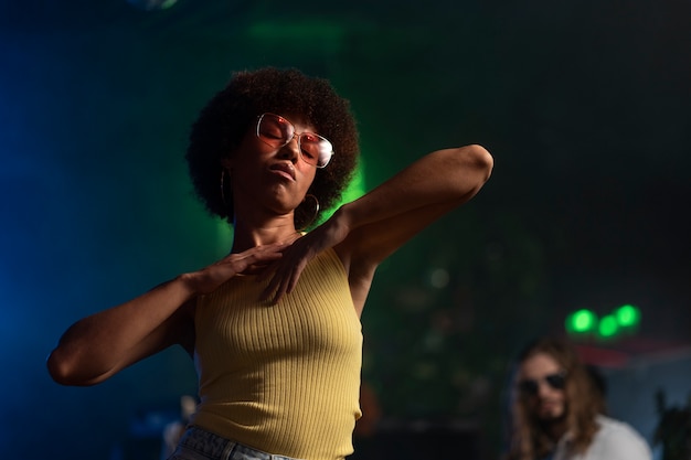 Foto gratuita donna giovane di taglio medio che balla a una festa techno