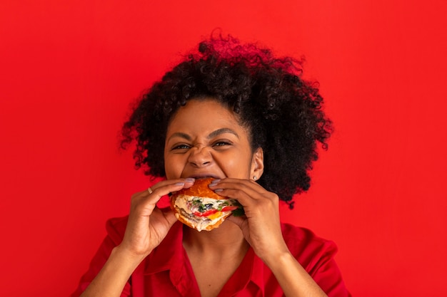 Молодая женщина среднего размера ест гамбургер