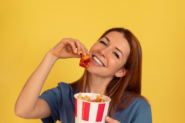 ファーストフードを食べるミディアムショットの若い女性