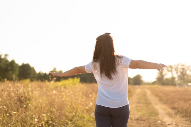 Medium shot of a young woman holding arms in the air