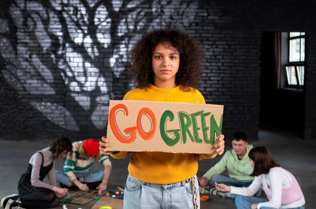 Medium shot young woman holding protest banner