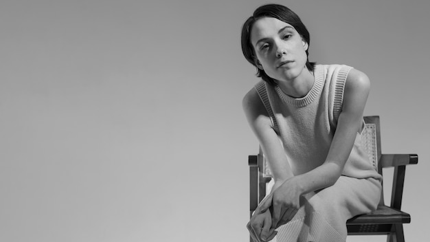 Free photo medium shot young woman posing on chair