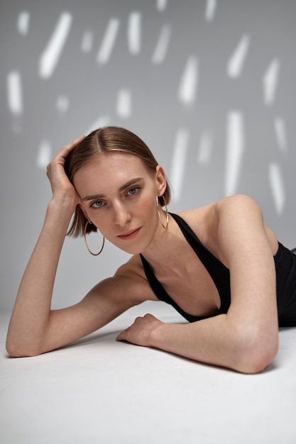 Medium shot young woman posing at studio