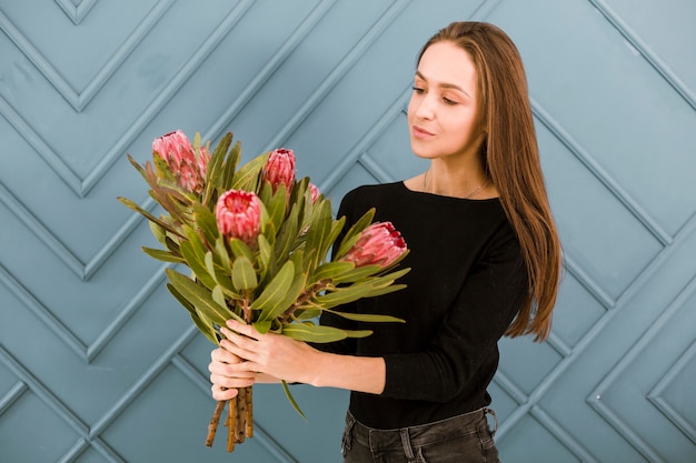 무료 사진 중간 샷 젊은 여자 꽃 포즈