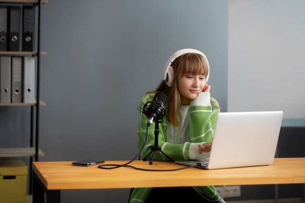 Medium shot young woman recording podcast