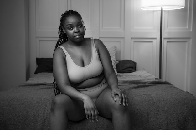 Medium shot young woman sitting in bed