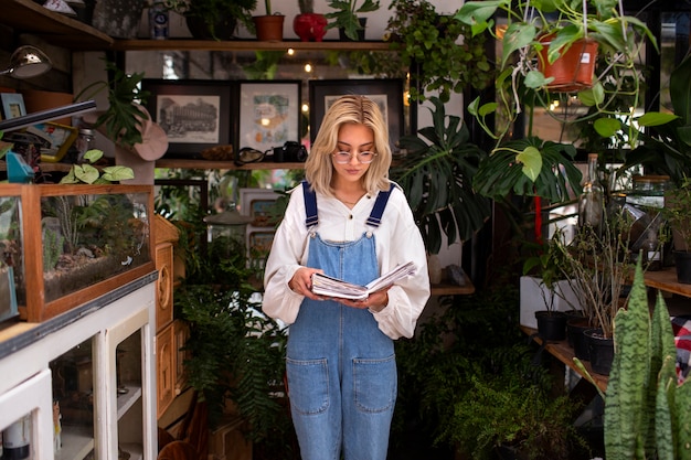무료 사진 식물에 둘러싸인 중간 샷 젊은 여자