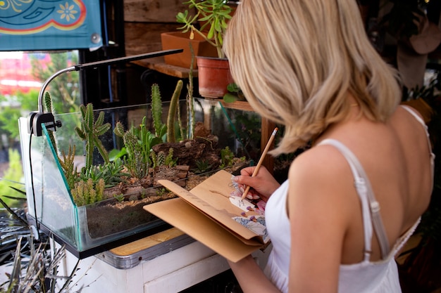 Free photo medium shot young woman surrounded by plants