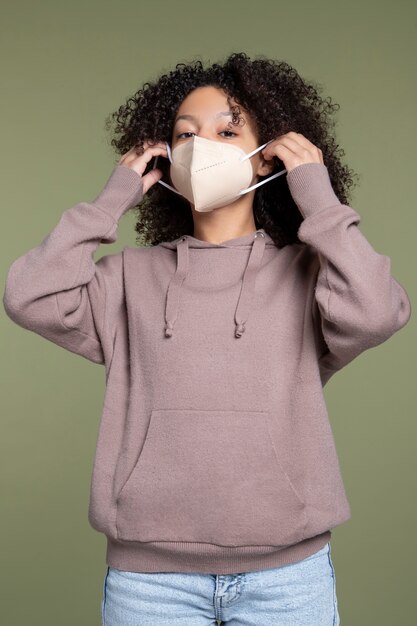 Medium shot young woman wearing mask