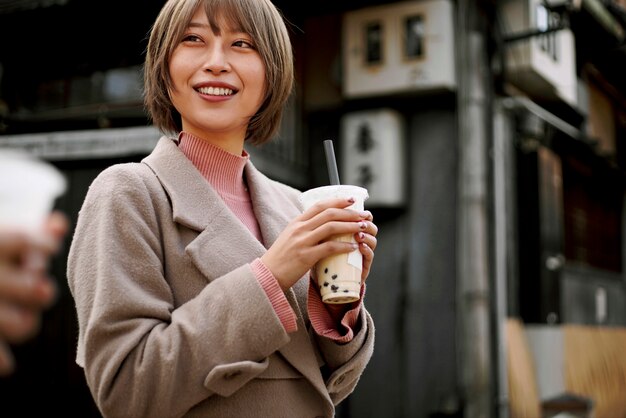 バブルティーを持つミディアムショットの若い女性