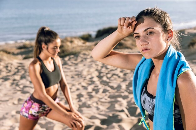 Medium shot young women relaxing after jogging