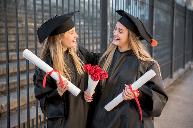 Medium view friends with bouquet of roses at graduation 