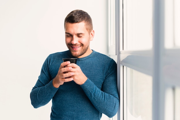 Medium view of man holding a cup of coffee