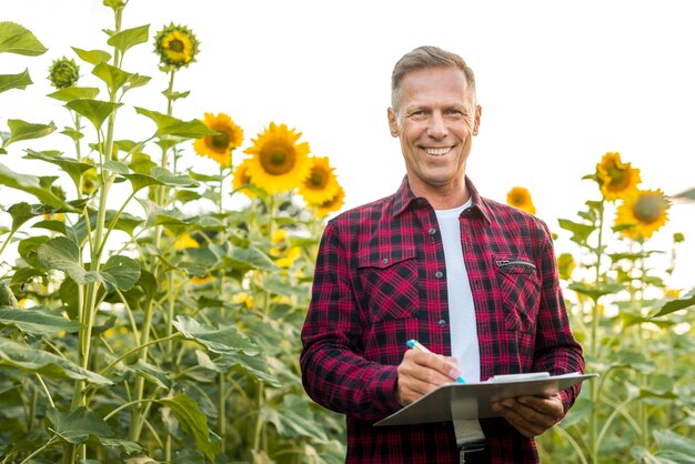 Medium view man with a clipboard in a field