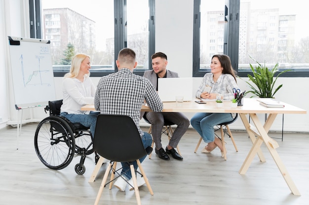 Foto gratuita incontro in ufficio con la donna in sedia a rotelle