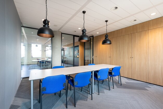 긴 나무 테이블과 의자가있는 현대적인 사무실의 회의실 내부