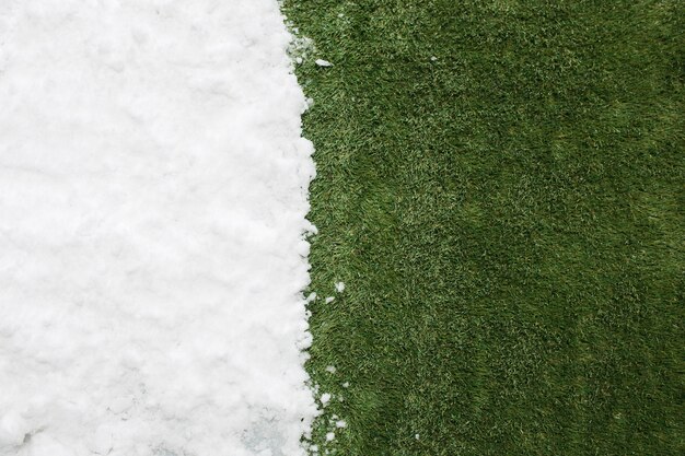Встреча белого снега и зеленой травы крупным планом. между зимой и весной концепции фон.