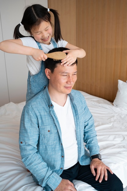 Meidum shot child brushing father's hair