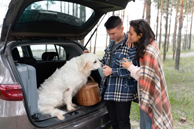 Meidum shot owners with cute dog