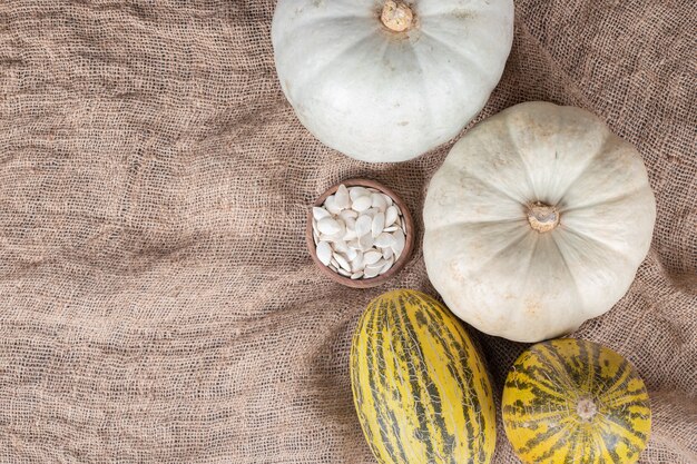 Melon and pumpkin on wooden board on marble.