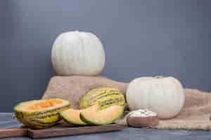 Free photo melon and pumpkin on wooden board on marble.