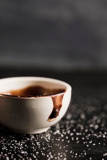 Melted chocolate in cup and sugar close-up