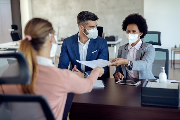 Members of human resource team having job interview with a candidate during coronavirus epidemic