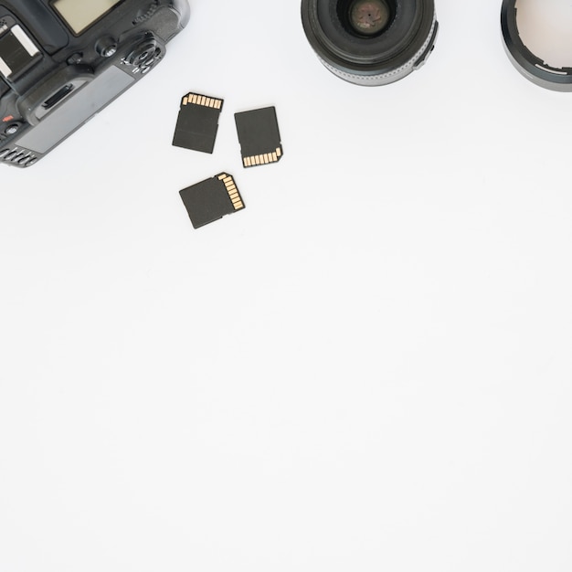 Memory cards; camera lens and professional dslr digital camera on white background