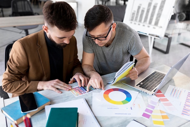 Free photo men analyzing a graph together at work