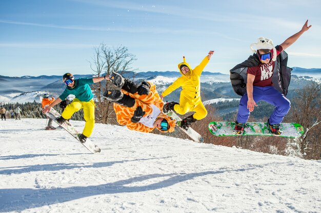 Мужчины пансионеры прыгают на своем сноуборде на фоне гор