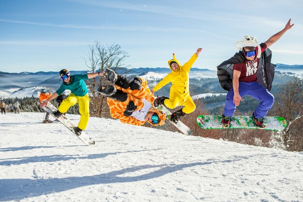 山を背景に彼のスノーボードでジャンプする男性ボーダー