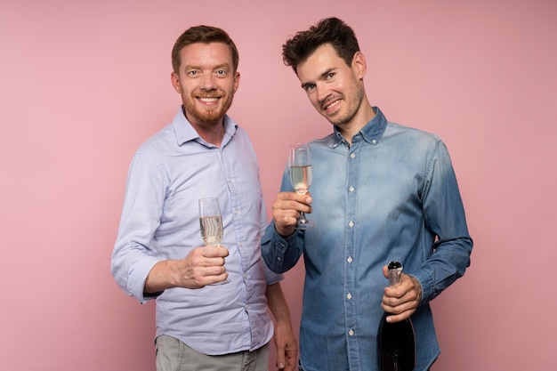 Men celebrating with champagne bottle and glasses