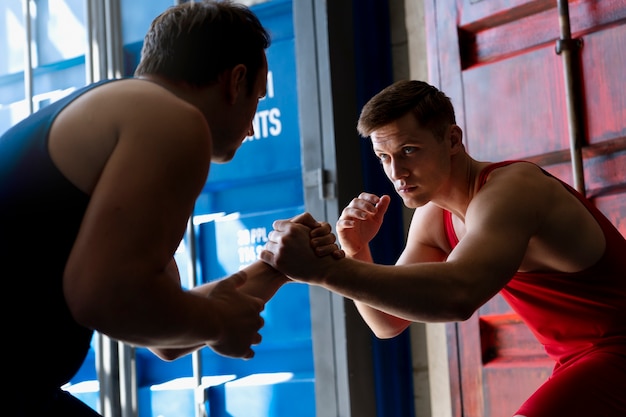 Free photo men demonstrating wrestling combat moves