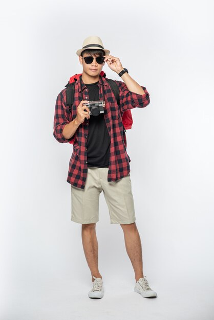 Мужчины, одетые для путешествий, в очках и шляпах Носят сумку и фотоаппарат