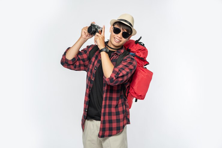 Free Photo men dressed to travel, wearing glasses and hats carrying a bag and carrying a camera