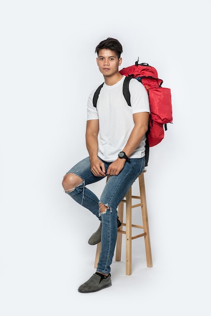 Men dressed to travel, wearing hats, and carrying a backpack