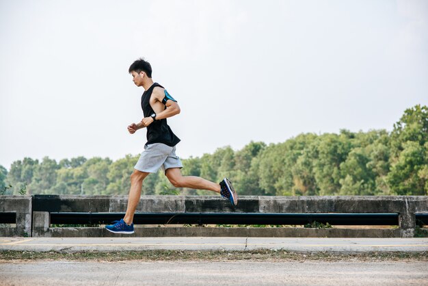 Free photo men exercise by running on the road on the bridge.