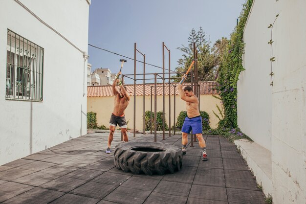 Men hitting with hammers on wheel