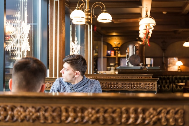 Free photo men looking out window in cafe