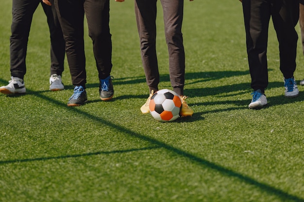 男性は公園でソーサーをします。ミニサッカーのトーナメント。黒のスポーツスーツを着た男。