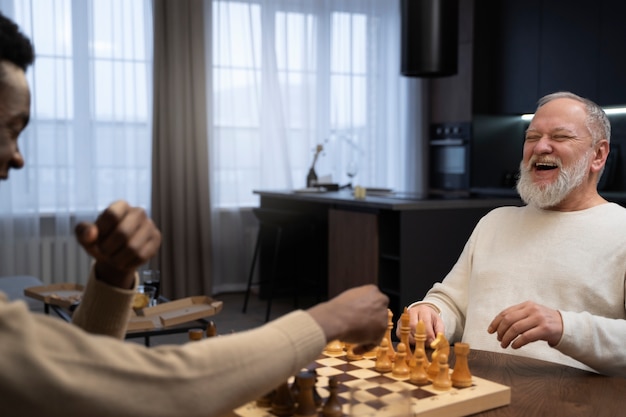 Free photo men playing chess indoors side view