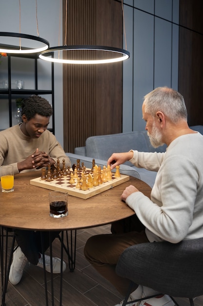 Free photo men playing chess indoors side view