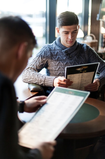 Men reading menu in cafe