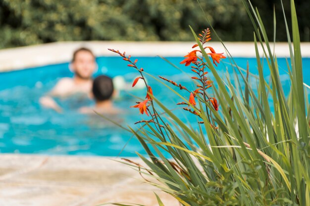 Men resting in swimming pool in yard